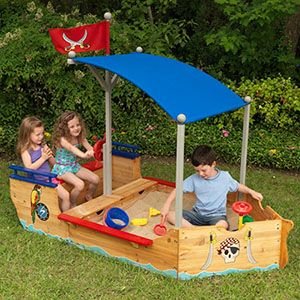 arenero infantil con forma de barco pirata. Los niños están jugando dentro de él